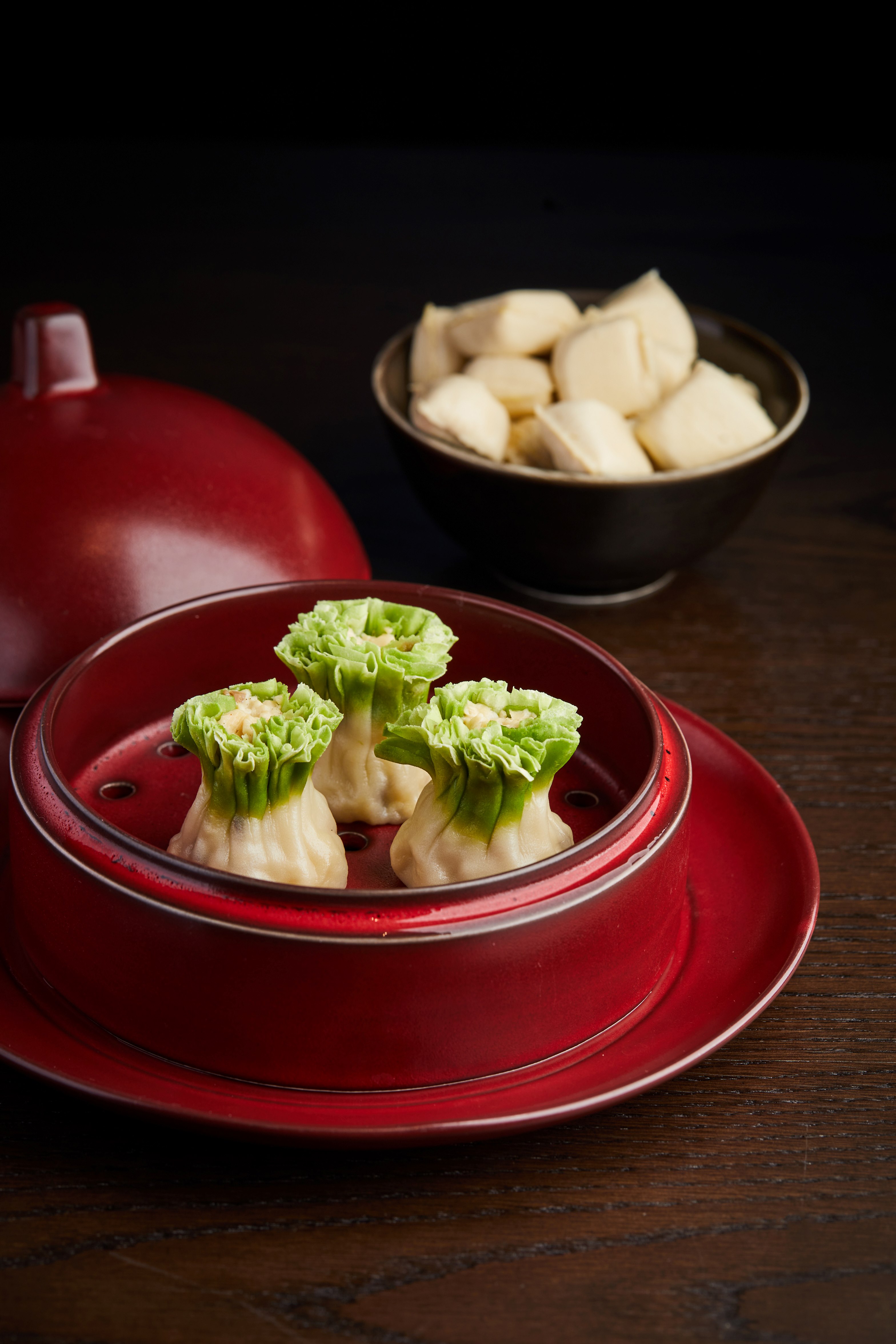 Food in a red bowl next to a bowl of food Description automatically generated